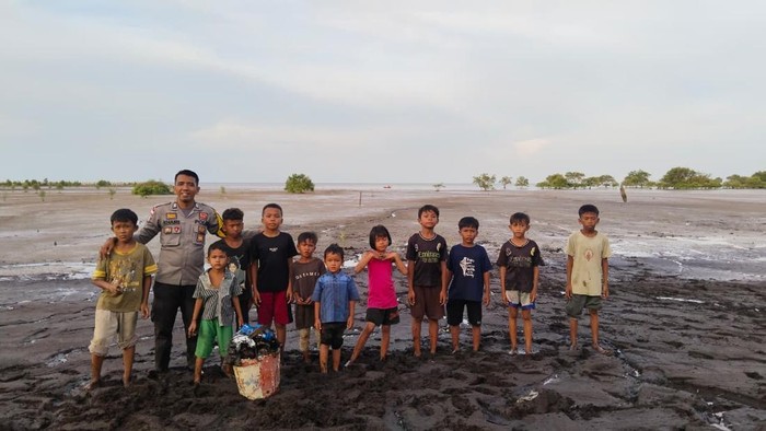 1761327608186-bhabinkamtibmas-di-kepulauan-meranti-ajak-anak-anak-suku-akit-menanam-mangrove-di-pantai-gelombang-cinta-1761319188615_169