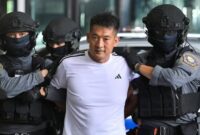 1763055765053-she-zhijiang-dikawal-polisi-thailand-saat-hendak-diekstradisi-ke-china-1763025618472_169