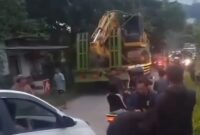 1763335669929-alat-berat-yang-diangkut-truk-tersangkut-kabel-listrik-di-bogor-1763317430363_169