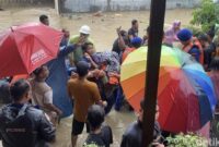 1764263179649-petugas-menggendong-nenek-sulasih-usai-dievakuasi-menggunakan-perahu-karet-dari-rumahnya-di-jalan-abadi-kecamatan-medan-sungga-1764251237155_169