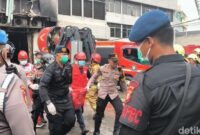 1765278393441-petugas-bolak-balik-membawa-kantong-jenazah-dari-dalam-gedung-kebakaran-di-jakpus-ke-ambulans-1765275592972_169