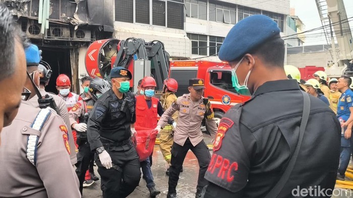 1765343194732-petugas-bolak-balik-membawa-kantong-jenazah-dari-dalam-gedung-kebakaran-di-jakpus-ke-ambulans-1765275592972_169
